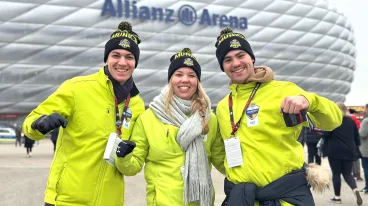 Drei Volunteers des NFL Munich Game 2024 vor der Allianz Arena