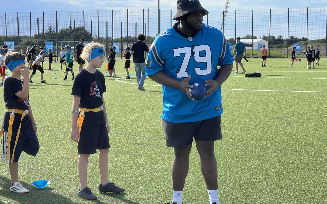 Der NFL-Spieler Ickey Ekwonu mit Kindern bei einem Flag Football Camp in München