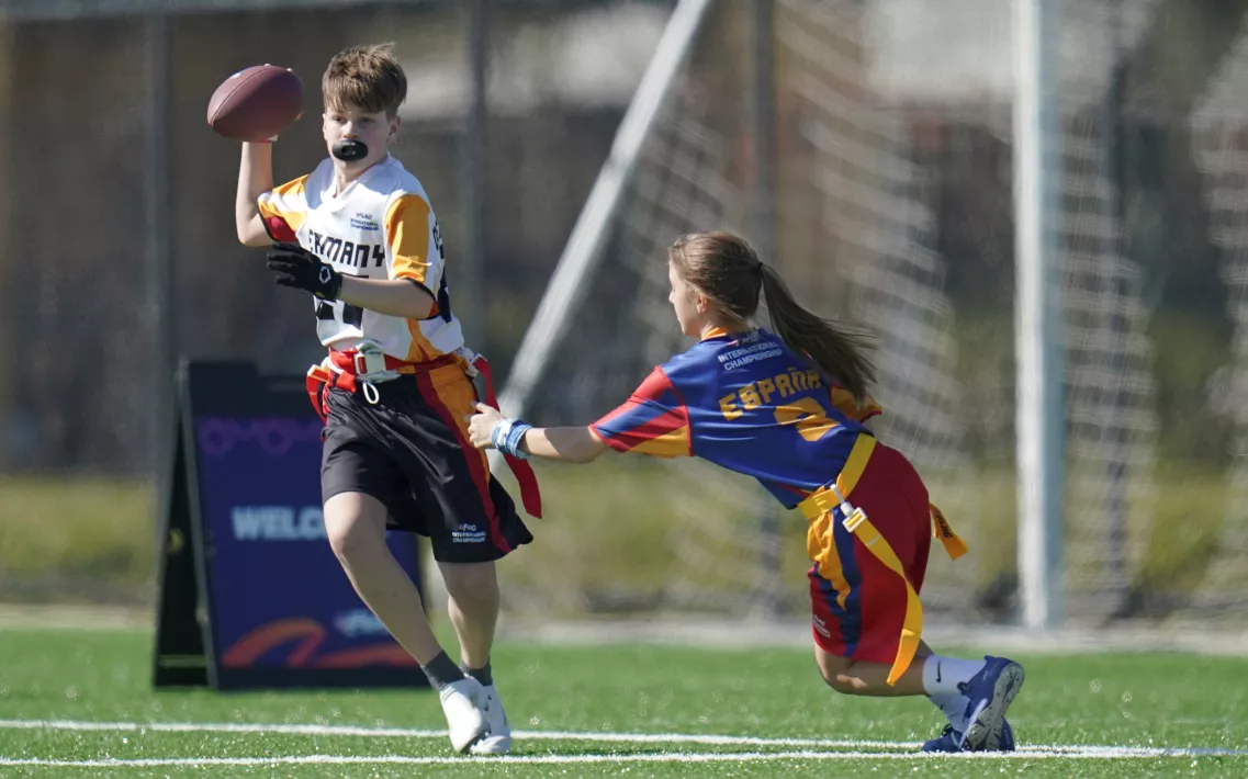 Eine Flag Football Spielerin versucht ihrem Gegenspieler die Flagge abzunehmen